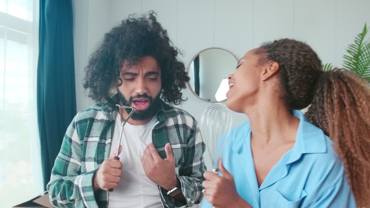 joven multinacional hombre y mujer canción de pie en el apartamento con cajas