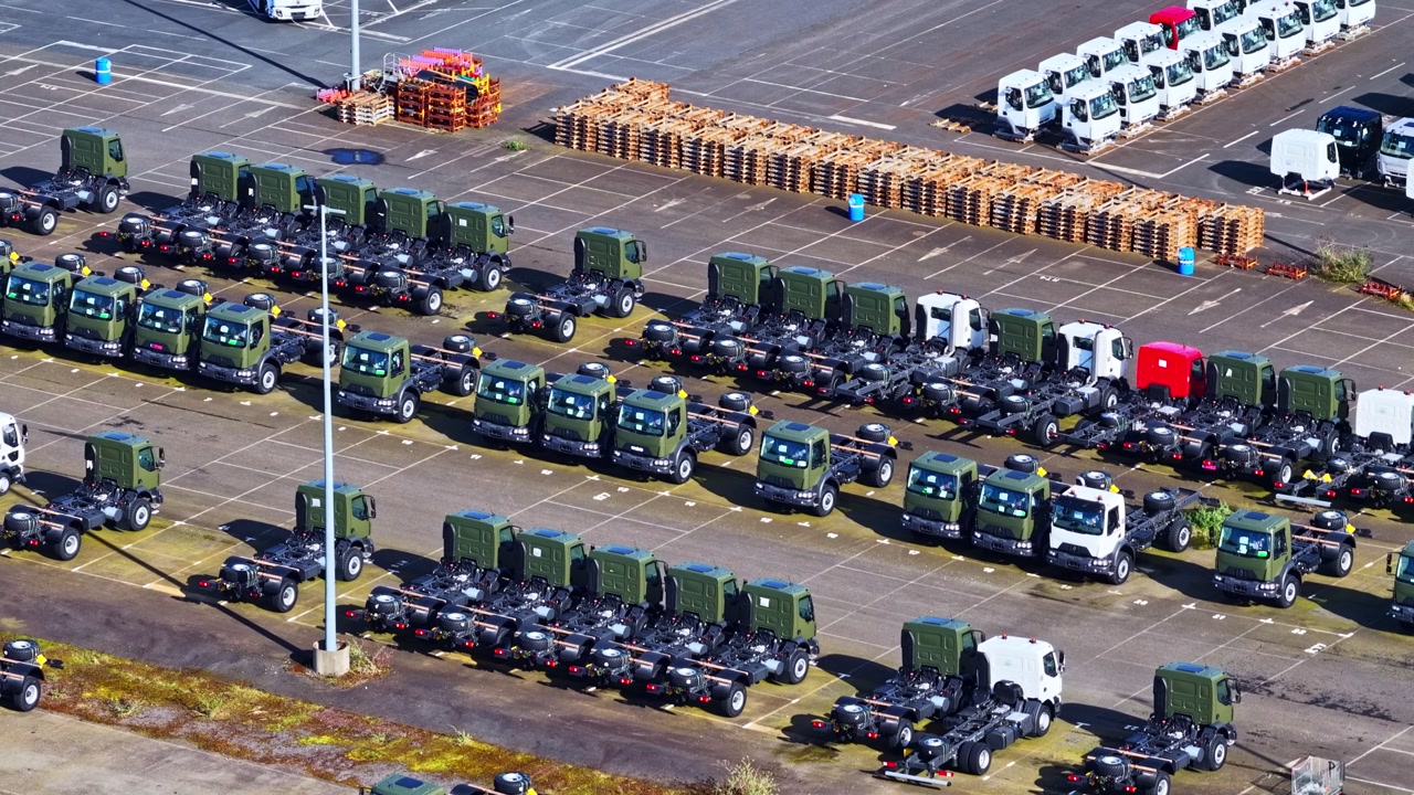 Fleet of new truck chassis parked in factory lot aerial view utility