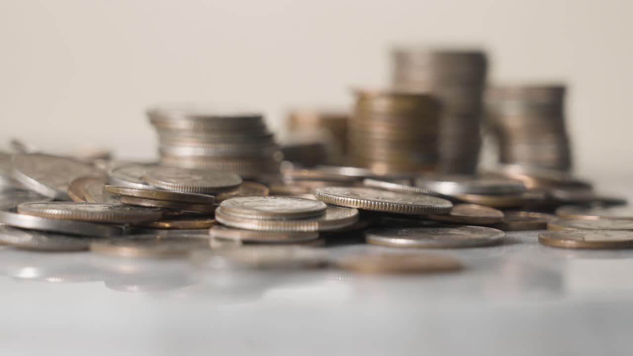 acercándose para mostrar un montón de monedas en una mesa