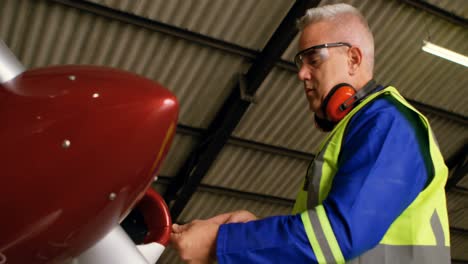 engineer repairing aircraft at aerospace hangar 4k