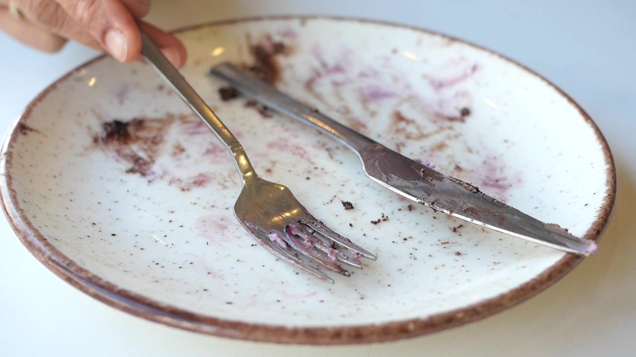 Empty Plate with Crumbs and Used Cutlery After Eating Dessert