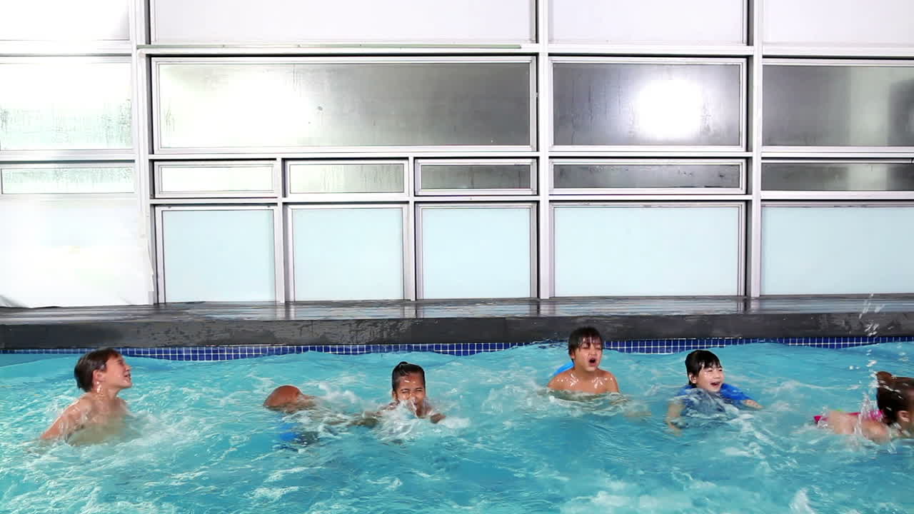 niños lindos saltando juntos a la piscina