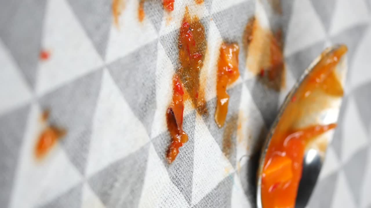 Primo piano di macchie di cibo su tessuto con cucchiaio