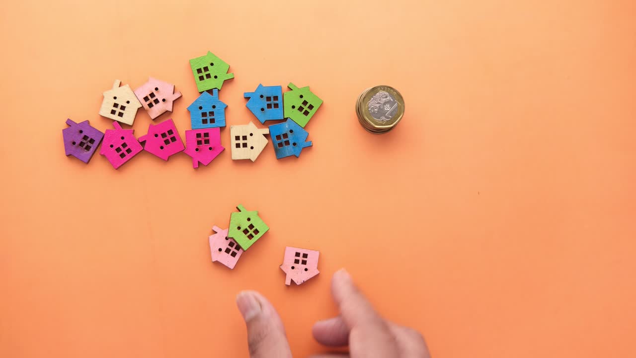 colocación de monedas a mano en casas en miniatura