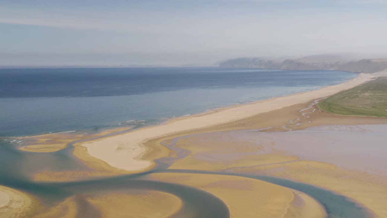 fotografía aérea de la playa roja y arenosa de raudasandur con el río y el océano en el fondo, islandia