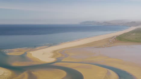 Toma-Aérea-Amplia-De-La-Playa-De-Arena-Roja-Y-Roja-De-Raudasandur-Con-Río-Y-Océano-Al-Fondo,-Islandia