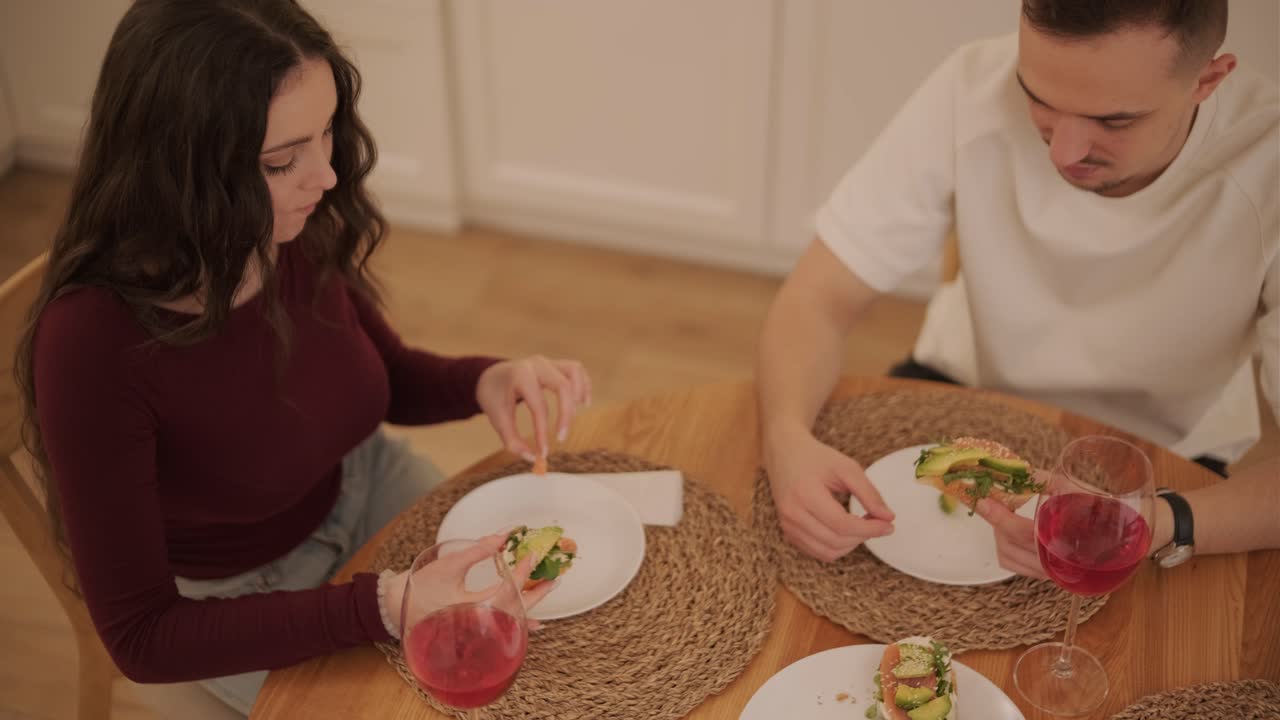 una pareja enamorada haciendo un sándwich en la cocina de la sala de estar