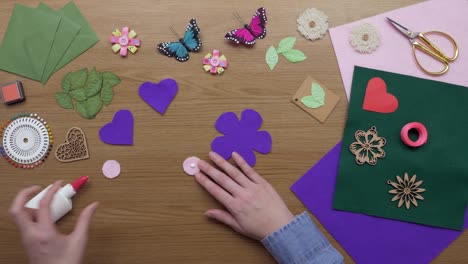 overhead aerial footage of woman sticking circle on fabric flower