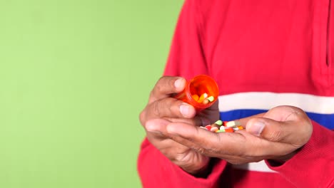 primer plano de la mano del hombre tomando la medicina