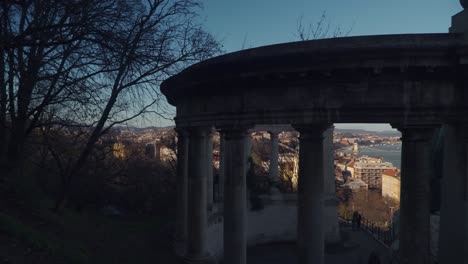 stone column structure at the top of a hill overlooking the danube river in budapest hungary - panning medium shot