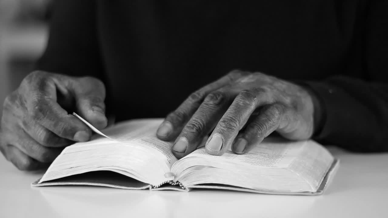Hands Turning Pages of a Book in Black and White