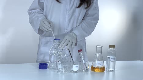 scientist conducts a potassium carbonate experiment, mixing chemicals in a lab with controlled lighting and precise movements