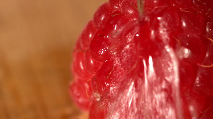Water pouring over a raspberry