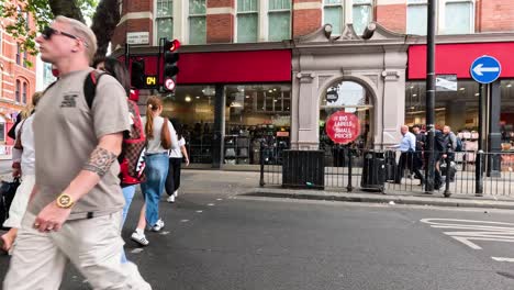 people crossing street near shops in london