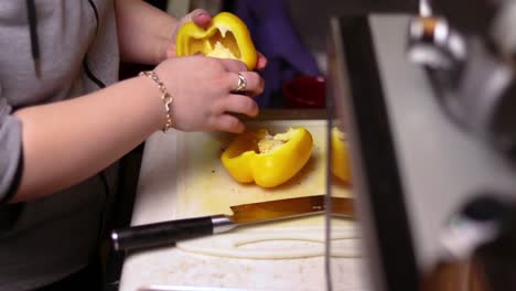 una vista lateral de cortar un pimiento amarillo por la mitad encima del mostrador de la cocina