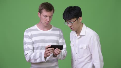 dos jóvenes empresarios multiétnicos usando el teléfono juntos