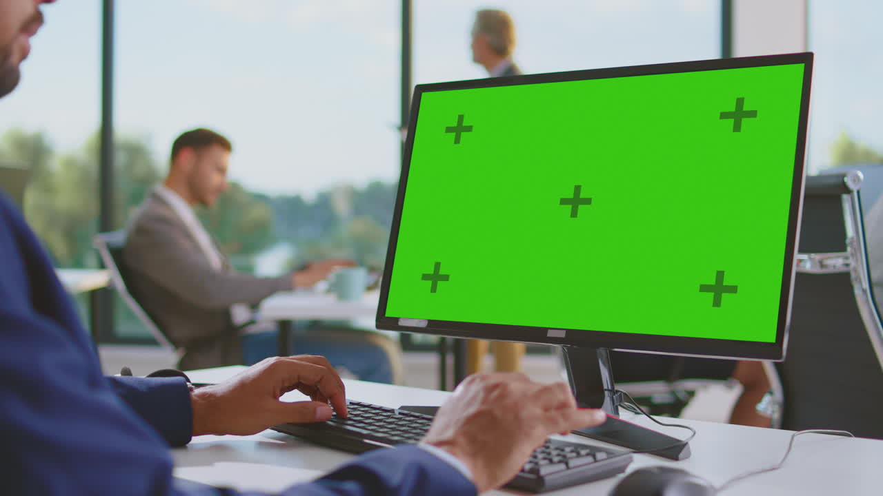 uomo d'affari che lavora davanti a un computer con uno schermo verde