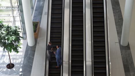 Hombres-De-Negocios-En-Una-Escalera-Mecánica-En-Un-Edificio-Moderno.