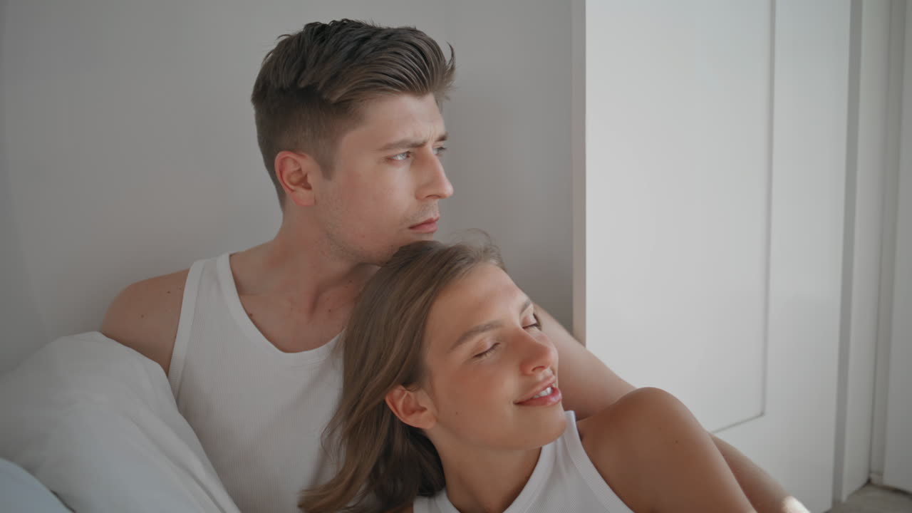 Romantic spouses relaxing home lying under blanket. Closeup loving man stroking