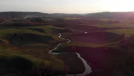 lärjeån river meander running through green wide meadows, sweden, aerial dolly out