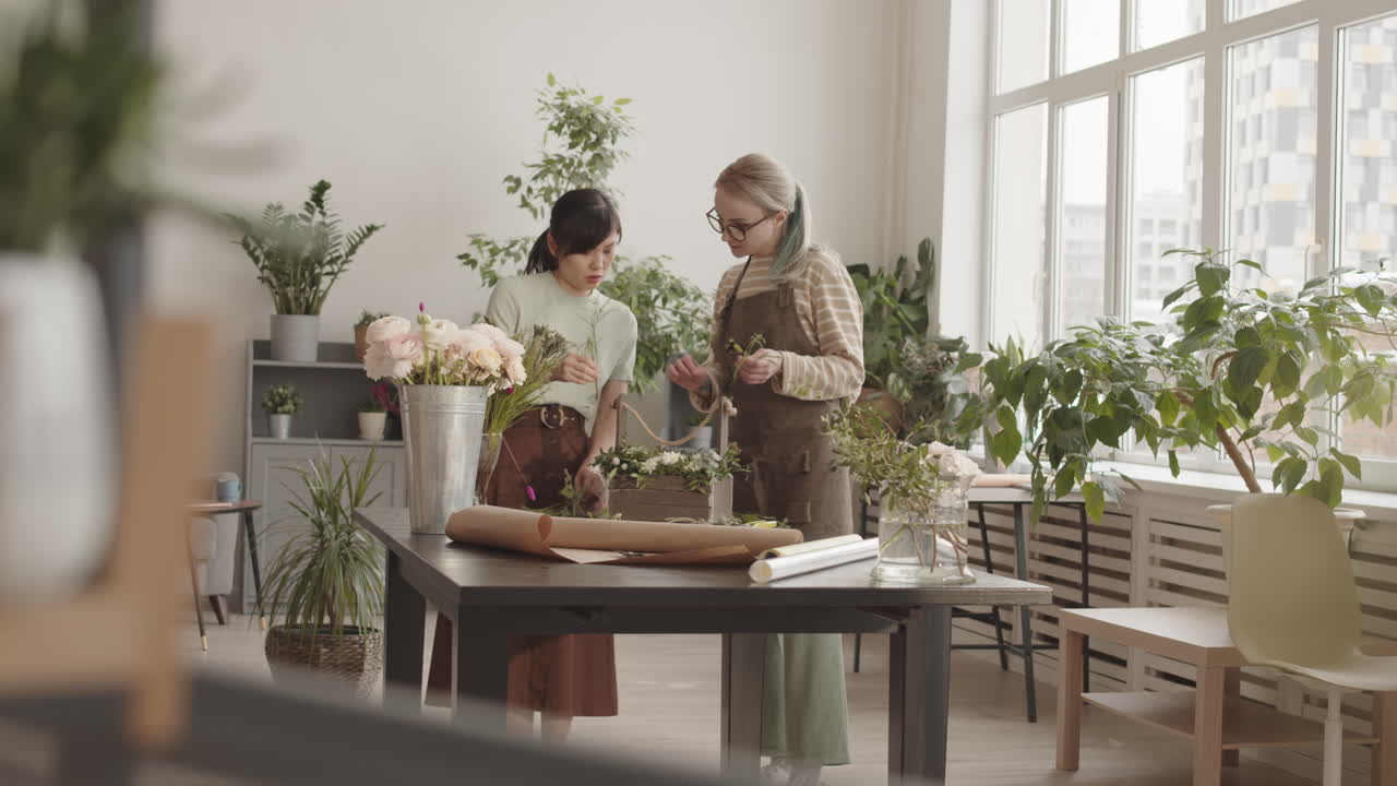 Two women making flower arrangements in a floral shop