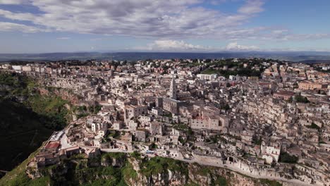 Panorama-De-La-órbita-Aérea-De-La-Ciudad-De-Matera-De-La-Unesco-En-La-Cima-Del-Valle-Rocoso,-Italia