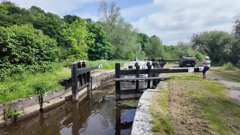 people and boats navigating a canal lock
