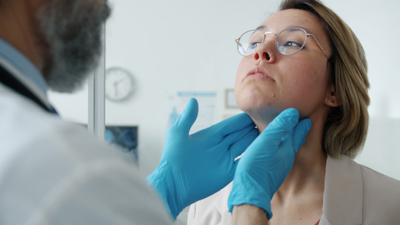 un médico examinando el cuello de un paciente