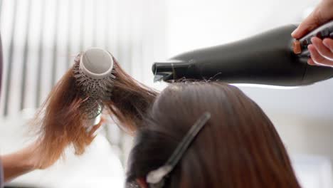 Kaukasische-Friseurin-Stylt-Die-Langen-Haare-Des-Kunden-Mit-Haartrockner-Und-Bürste,-Zeitlupe