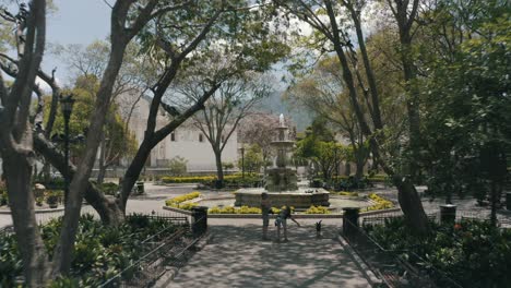 Drohnenantenne,-Die-Tief-Auf-Einem-Schönen-Park-Mit-Einem-Brunnen-In-Antigua-Guatemala,-Mittelamerika-Fliegt