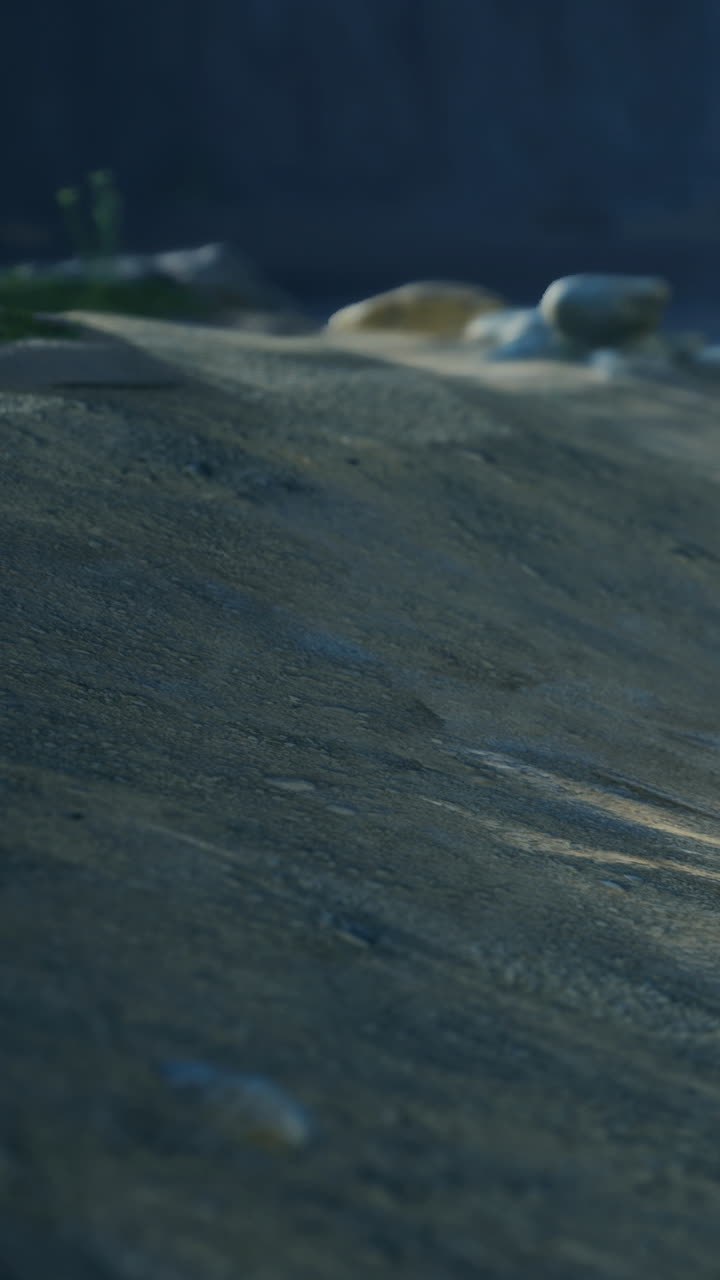 Rocky terrain with pebbles and shadows at the mountains during sunset