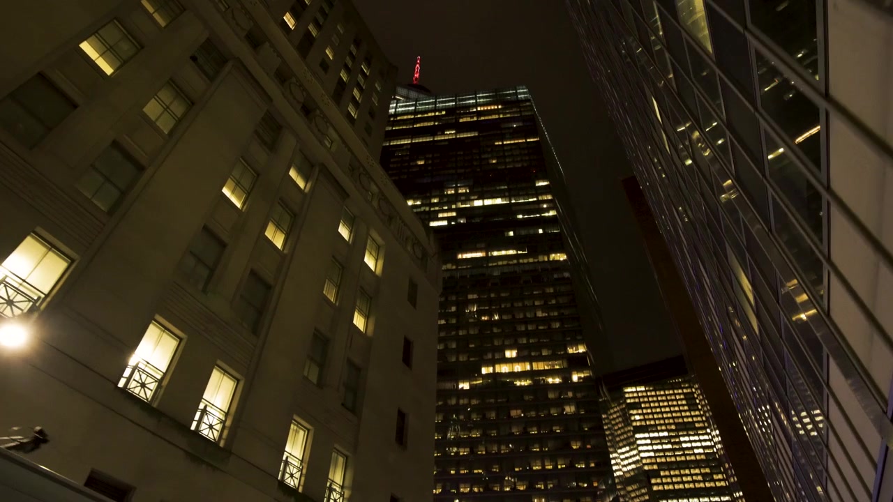 Imagem noturna de um edifício de Manhattan inclinando-se para cima e finalmente revelando sua altura colossal