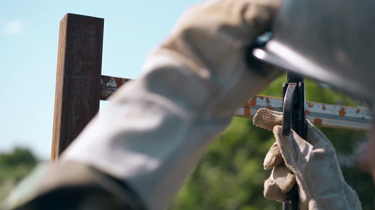 장갑 용접에서 클로즈업 노동자 시골 집 울타리의 세부 사항