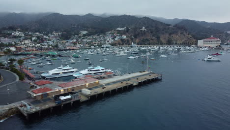 Amplia-Toma-Panorámica-Aérea-De-Los-Barcos-De-Pasajeros,-El-Puerto-Y-El-Casino-De-Avalon-Bay,-Santa-Catalina