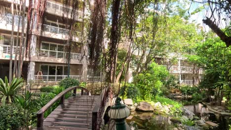 person walking across a bridge in a garden