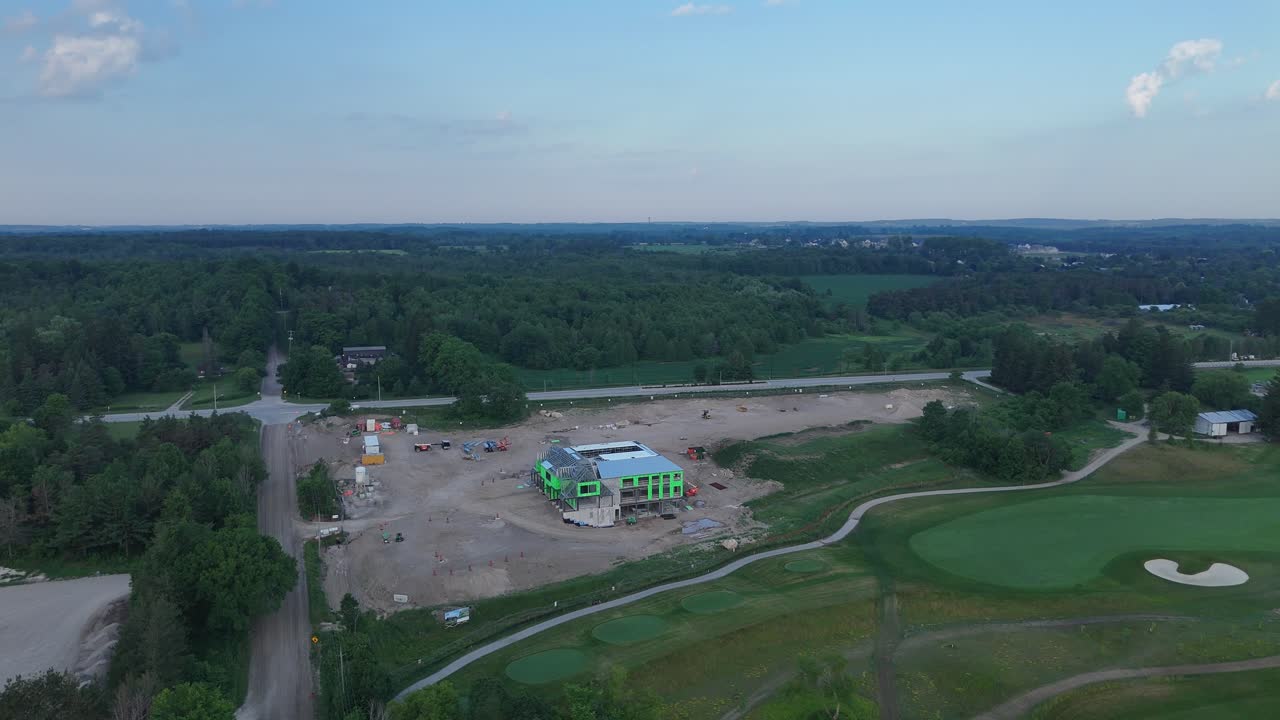 Drone aerial shot showing Golf Canada headquarters under construction at TPC Toronto Osprey Valley, with green walls, surrounding roads, golf course and forest