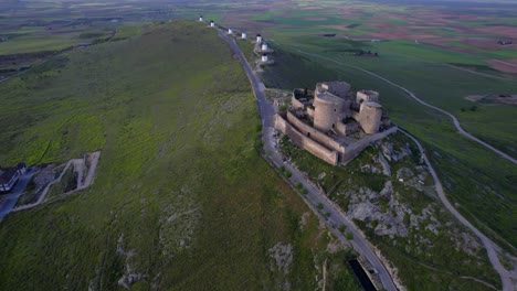 Aerial-top-view-of-medieval-castle-and-windmills-in-line-on-top-of-hill