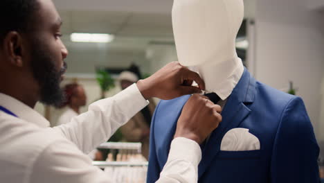 el hombre arregla el maniquí en la tienda de moda