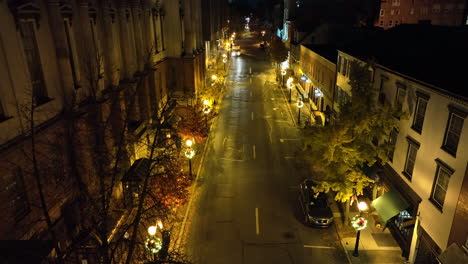 rising aerial of traffic on dark one way urban city street at night