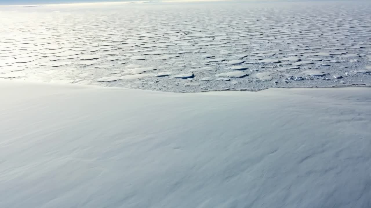 A breathtaking and expansive vista showcases an untouched landscape blanketed in pristine snow, all beneath a clear blue sky in a remote, frigid location