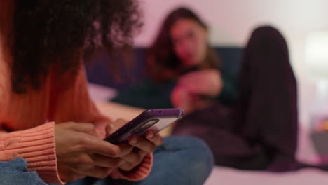 dos mujeres jóvenes usando teléfonos inteligentes