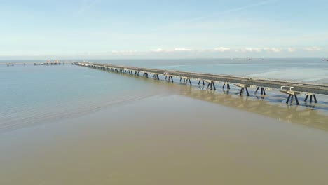 aerial view of industrial oil pier and shadow on shallow sandy coastline of north sea, germany