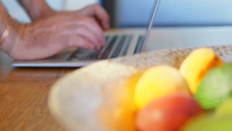 hombre usando computadora portátil en la cocina en casa 4k