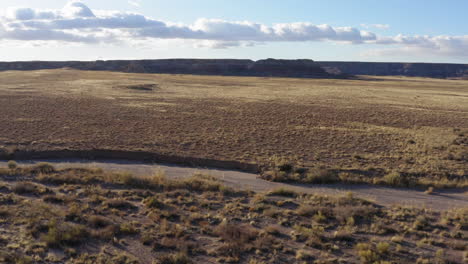 low aaltitude drone flying over a dusty badland on a sunny day