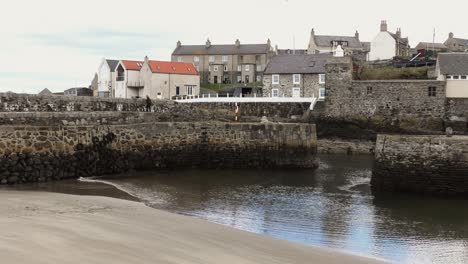 portsoy harbour lady walks along harbour wall