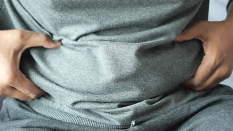 man with belly fat touching his stomach