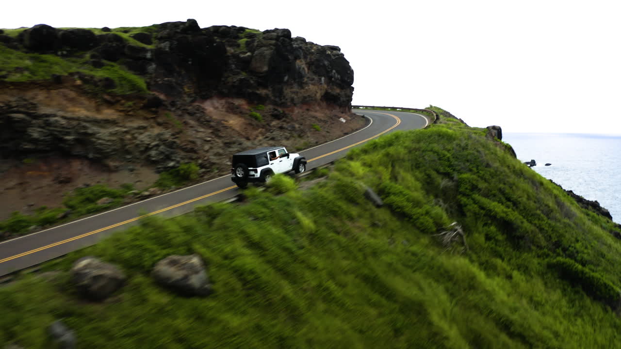 Aerial View, Jeep Drives Around Cliff On Maui Coastline, Hawaii.