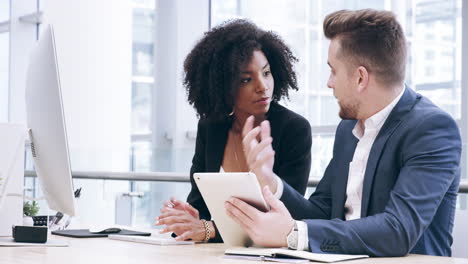 two-businesspeople-working-together-in-an-office