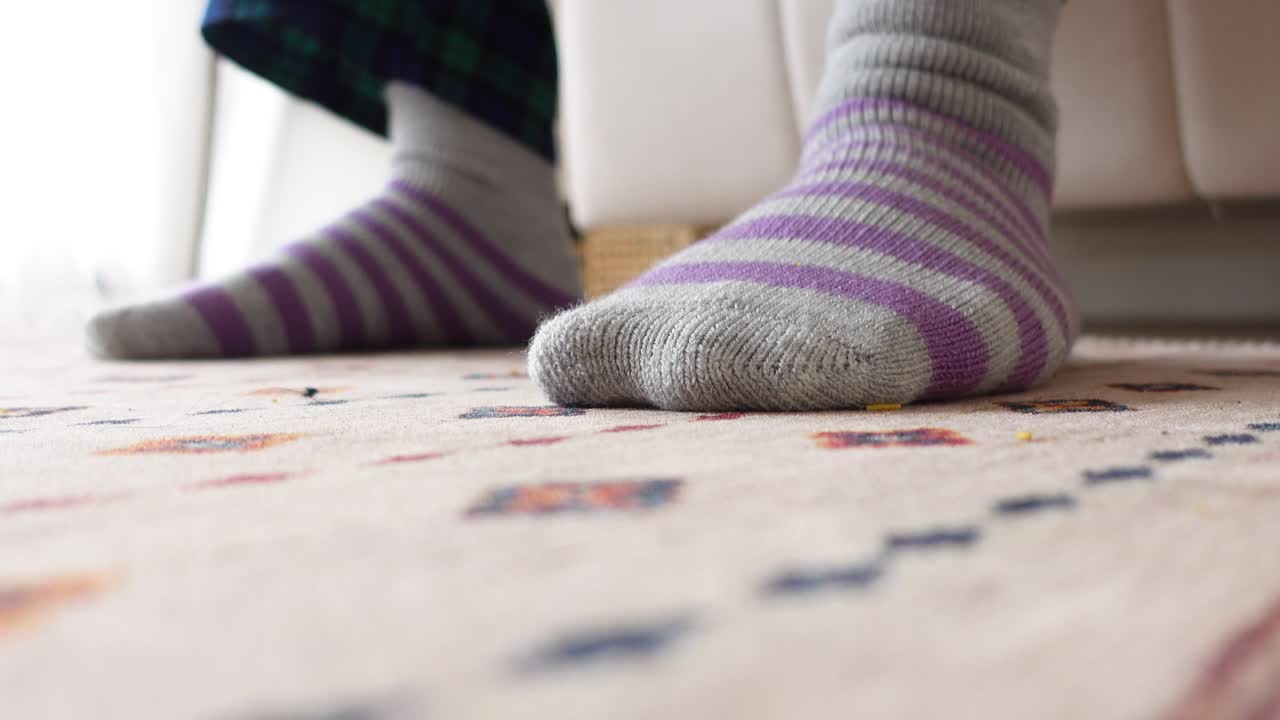 Feet in striped socks on a carpet