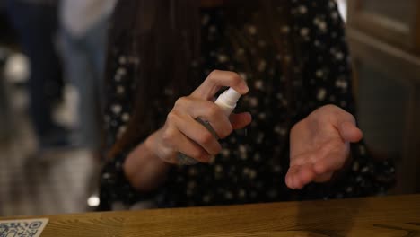 mujer aplicando desinfectante de manos en un restaurante